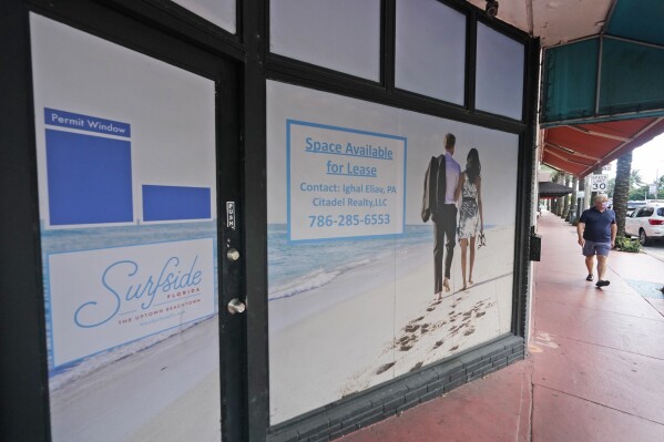 FILE - A pedestrian walks past an empty business available for lease, Oct. 12, 2020, in downtown Surfside, Fla. Stocks in companies that own apartment buildings are holding up better than most other real estate investment trusts, as a tough U.S. housing market keeps demand for rental housing healthy and tenant turnover low. (AP Photo/Wilfredo Lee, File)