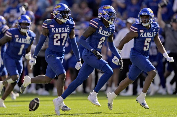 Kansas cornerback Cobee Bryant (2) celebrates with teammates after intercepting a pass during the first half of an NCAA college football game against Houston, Saturday, Oct. 19, 2024, in Kansas City, Mo. (AP Photo/Charlie Riedel)