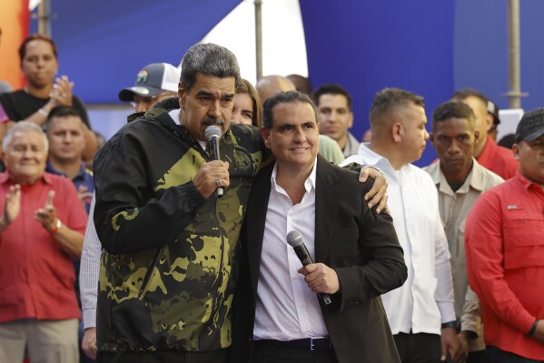 FILE - Venezuela's President Nicolas Maduro and Alex Saab stand in an embrace during an event marking the anniversary of the 1958 coup that overthrew dictator Marcos Perez Jimenez, in Caracas, Venezuela, Jan. 23, 2024. (AP Photo/Jesus Vargas, File)