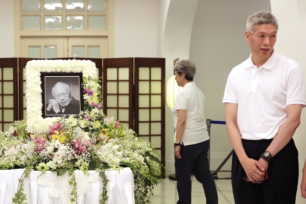 FILE - Prime Minister Lee Hsien Loong's brother, Lee Hsien Yang, right, receives friends and family members paying their respects to the late Lee Kuan Yew during a private family wake at the Istana or Presidential Palace in Singapore, March 24, 2015. (AP Photo/Wong Maye-E, File)