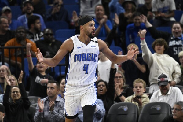 Orlando Magic guard Jalen Suggs (4) reacts after scoring a basket against the Philadelphia 76ers during the first half of a preseason NBA basketball game, Friday, Oct. 18, 2024, in Orlando, Fla. (AP Photo/Phelan M. Ebenhack)