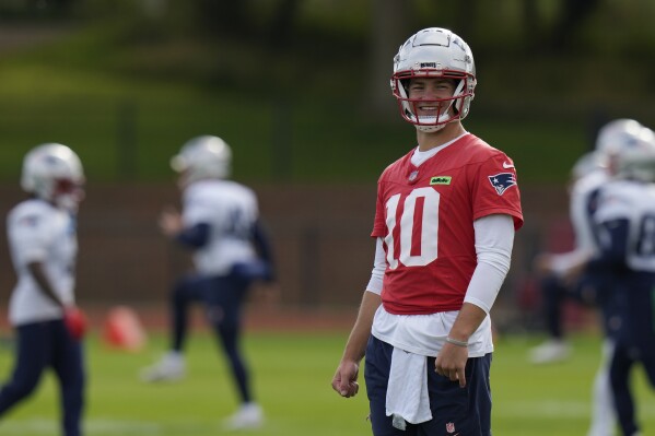 New England Patriots quarterback Drake Maye (10) smiles during NFL football practice, Friday, Oct. 18, 2024, in Harrow, England. (AP Photo/Steve Luciano)