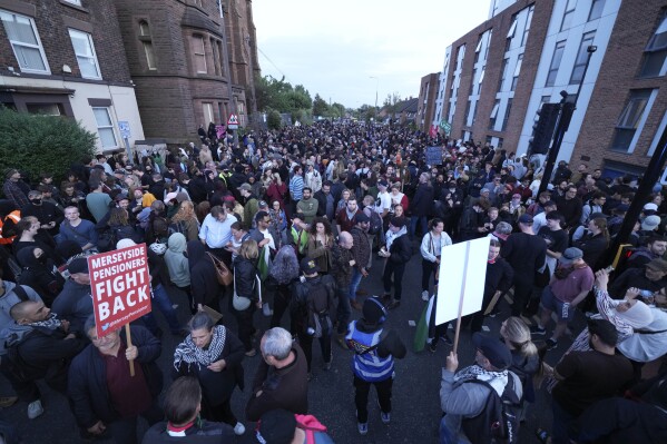 Counter protesters gather in Liverpool, Wednesday, Aug. 7, 2024 ahead of anti-immigration groups planning to target dozens of locations throughout the country following a week of rioting fueled by misinformation over a stabbing attack against young girls.(AP Photo/Jon Super)