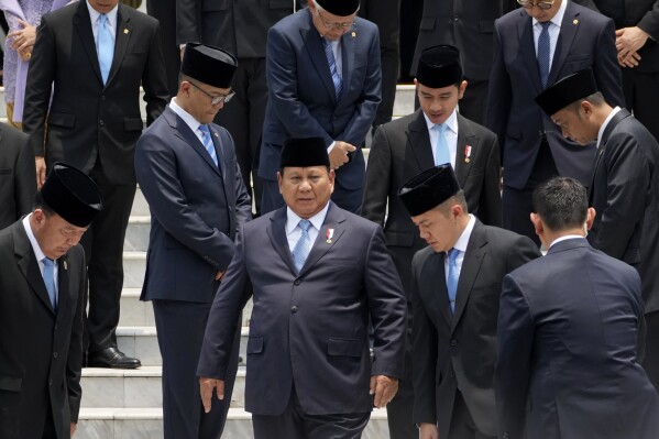 Indonesian President Prabowo Subianto, center, takes his position for a group photo with newly-appointed cabinet ministers after their swearing-in ceremony at Merdeka Palace in Jakarta, Indonesia, Monday, Oct. 21, 2024. (AP Photo/Achmad Ibrahim)