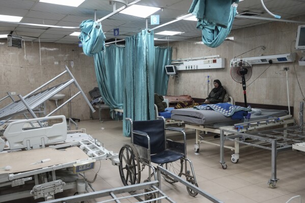 A woman sits on a bed in a room of the Al-Aqsa Martyrs hospital in Deir al Balah, Gaza Strip, Sunday, Aug. 25, 2024. (AP Photo/Abdel Kareem Hana)