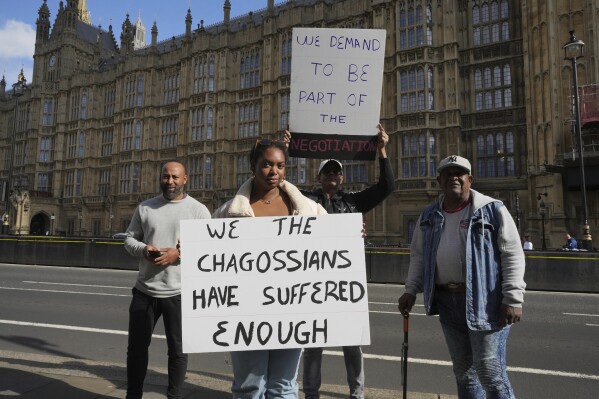 Chagossians Whitney Tranquille, center, attends a protest to response the U.K. announcement to agree to hand sovereignty of the long-contested Chagos Islands to Mauritius and against their "Exclusion" from Chagos negotiations, outside the House of Parliament, in London, Monday, Oct. 7, 2024. (AP Photo/Kin Cheung)