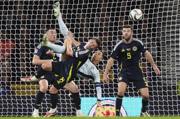 Portugal's Cristiano Ronaldo, center right, attempts an acrobatic shot on goal during the UEFA Nations League soccer match between Scotland and Portugal at Hampden Park in Glasgow, Scotland, Tuesday, Oct. 15, 2024. (Andrew Milligan/PA via AP)