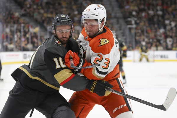 Vegas Golden Knights center Nicolas Roy (10) and Anaheim Ducks center Mason McTavish (23) collide during the second period of an NHL hockey game Sunday, Oct. 13, 2024, in Las Vegas. (AP Photo/Ian Maule)