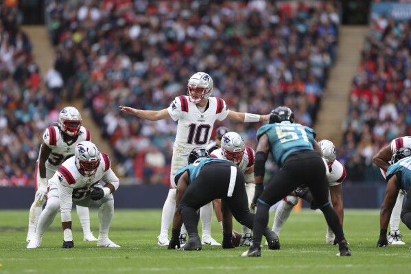 New England Patriots quarterback Drake Maye (10) calls an audible during the first half of an NFL football game against the Jacksonville Jaguars, Sunday, Oct. 20, 2024, in London. (AP Photo/Ian Walton)