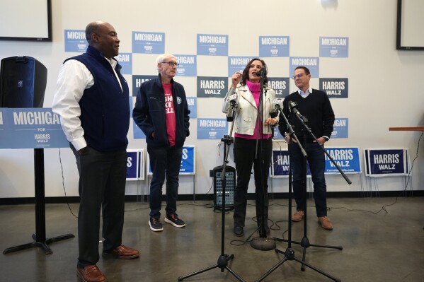 Chair of the Democratic National Committee Jaime Harrison, left, Wisconsin Gov. Tony Evers, Michigan Gov. Gretchen Whitmer and Pennyslvania Gov. Josh Shapiro talk to volunteers during a campaign event, Thursday, Oct. 17, 2024, in Flint, Mich. (AP Photo/Carlos Osorio)