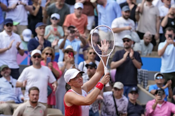 Iga Swiatek of Poland celebrates after defeating Anna Karolina Schmiedlova of Slovakia in their women's bronze medal match, at the 2024 Summer Olympics, Friday, Aug. 2, 2024, at the Roland Garros stadium in Paris, France. (AP Photo/Andy Wong)