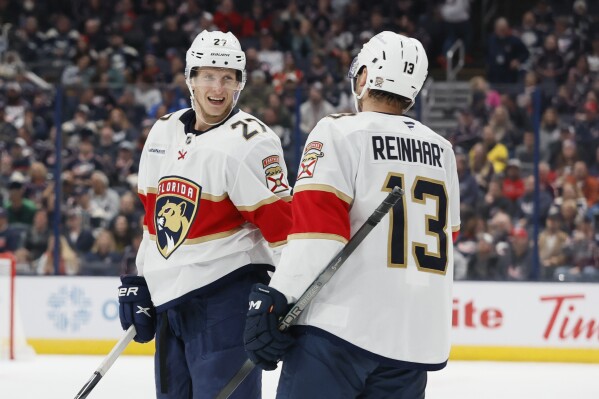 Florida Panthers' Eetu Luostarinen, left, celebrates his goal against the Columbus Blue Jackets with teammate Sam Reinhart during the third period of an NHL hockey game Tuesday, Oct. 15, 2024, in Columbus, Ohio. (AP Photo/Jay LaPrete)