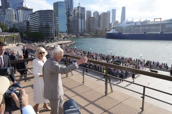 Britain's King Charles III, right, waves to the crowd beside Queen Camilla during their visit to the Sydney Opera House in Sydney, Australia, Tuesday, Oct. 22, 2024. (AP Photo/Mark Baker, Pool)