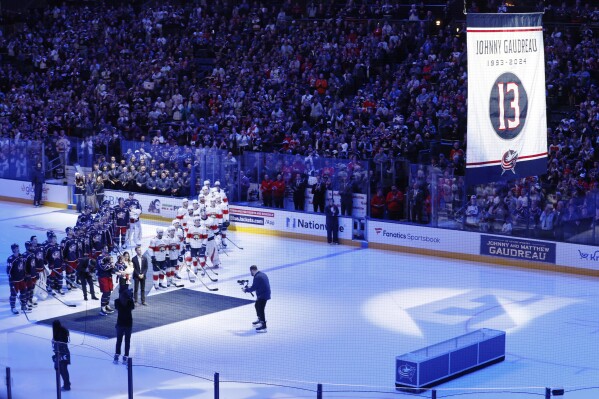 Blue Jackets' Johnny Gaudreau's family watches a #13 banner being raised during a ceremony before the start of an NHL hockey game between the Columbus Blue Jackets and the Florida Panthers. Tuesday, Oct. 15, 2024, in Columbus, Ohio. (AP Photo/Jay LaPrete)