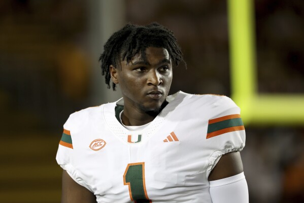 FILE - Miami quarterback Cam Ward (1) warms up before an NCAA college football game against California in Berkeley, Calif., Oct. 5, 2024. (AP Photo/Jed Jacobsohn, File)