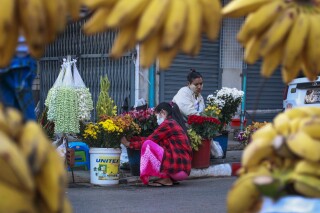 FILE - Woman arrange flowers at a street market in Yangon, Myanmar, on Feb. 2, 2021. Myanmar was a rising star in Southeast Asia before its military seized power three years ago in a takeover that has brought civil strife and a tightening vise of sanctions, undoing years of progress and leaving the economy 10% smaller than it was in 2019. (AP Photo/Thein Zaw, File)