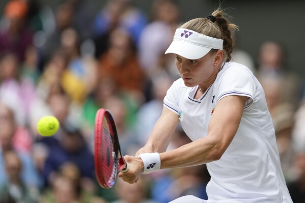 Elena Rybakina of Kazakhstan plays a backhand return to Elina Svitolina of Ukraine during their quarterfinal match at the Wimbledon tennis championships in London, Wednesday, July 10, 2024. (AP Photo/Kirsty Wigglesworth)