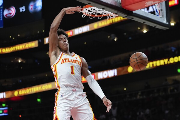 El alero de los Hawks de Atlanta, Jalen Johnson (1), anota en la primera mitad de un partido de baloncesto de la NBA de pretemporada contra los 76ers de Filadelfia, el lunes 14 de octubre de 2024, en Atlanta. (AP Foto/John Bazemore)