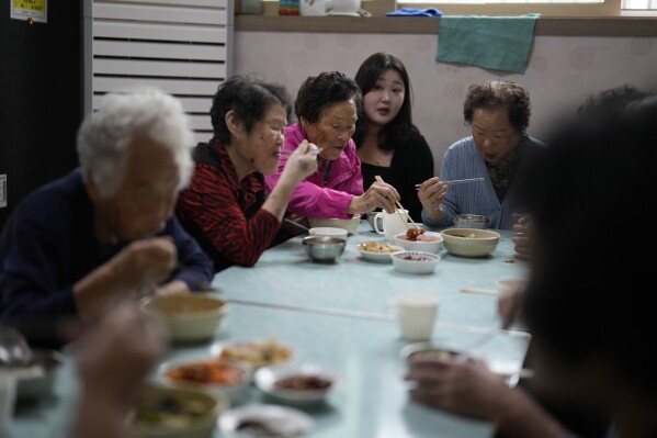 Leader Park Jeom-sun, 82-year-old, center, and other members of Suni and the Seven Princesses eat lunch before their training at senior community center in Chilgok, South Korea, Thursday, Oct. 3, 2024. (AP Photo/Lee Jin-man)