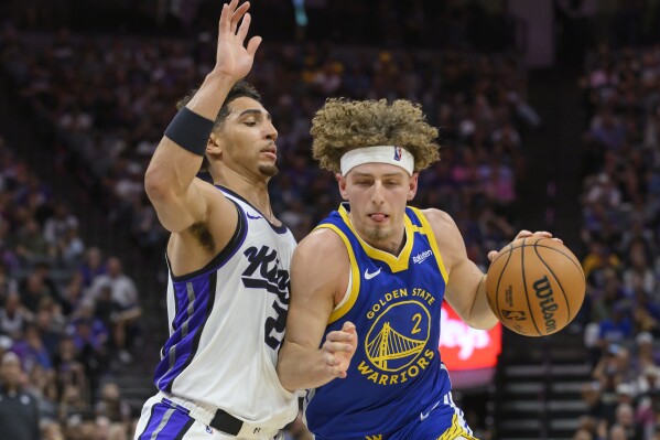 Golden State Warriors guard Brandin Podziemski (2) is guarded by Sacramento Kings guard Colby Jones (20) during the second half of a preseason NBA basketball game in Sacramento, Calif., Wednesday, Oct. 9, 2024. (AP Photo/Randall Benton)