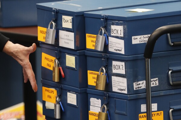 FILE - Ballot boxes are brought in to for a ranked choice voting tabulation in Augusta, Maine, Nov. 12, 2018. (AP Photo/Robert F. Bukaty, File)