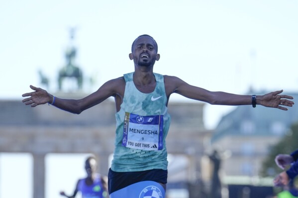 Milkesa Mengesha from Ethiopia celebrates as he crosses the finish line to win the men's division of the Berlin Marathon in Berlin, Germany, Sunday, Sept. 29, 2024. (AP Photo/Ebrahim Noroozi)