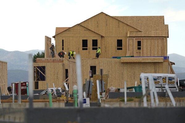 FILE - Workers toil on new homes in a housing development Tuesday, June 25, 2024, in Loveland, Colo. After showing signs of strengthening early this year, sales of new U.S. homes fell in April and May from a year earlier by 7.7% and 16.5%, respectively. (AP Photo/David Zalubowski, File)