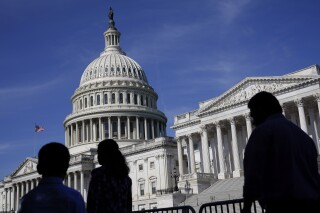 FILE - People walk outside the U.S Capitol building in Washington, June 9, 2022. President Joe Biden goes into Thursday's State of the Union address with an expanded plan to raise corporate taxes. He would use the proceeds to trim budget deficits and cut taxes for the middle class.(AP Photo/Patrick Semansky, File)