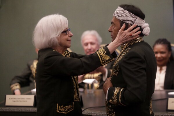 Writer Fernanda Montenegro holds Indigenous writer and environmental activist Ailton Krenak during his admission ceremony at the Brazilian Academy of Letters in Rio de Janeiro, Brazil Friday, April 5, 2024. Krenak is the first Indigenous person to be elected to the academy. (AP Photo/Bruna Prado)