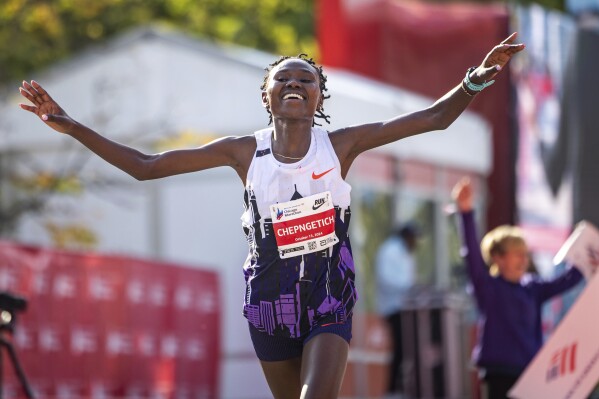 Ruth Chepngetich, from Kenya, crosses the finish line of the Chicago Marathon to win the women's professional division and break the women's marathon world record in Grant Park on Sunday, Oct. 13, 2024. (Tess Crowley/Chicago Tribune via AP)