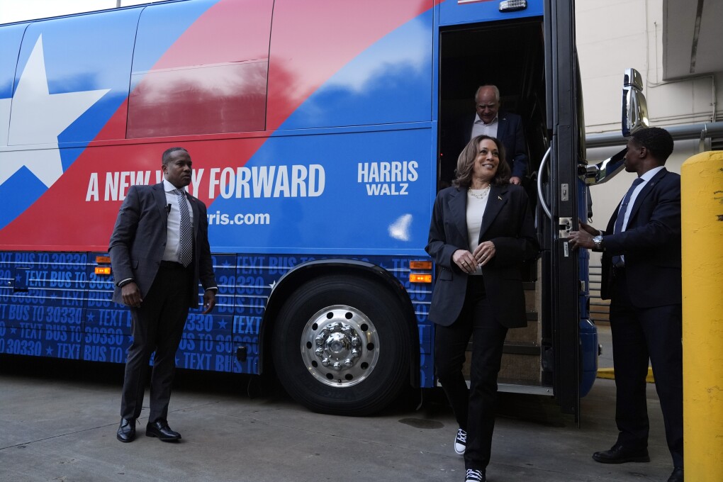 Democratic presidential nominee Vice President Kamala Harris and her running mate Minnesota Gov. Tim Walz exit their campaign bus in Savannah, Ga., Wednesday, Aug. 28, 2024. (AP Photo/Jacquelyn Martin)