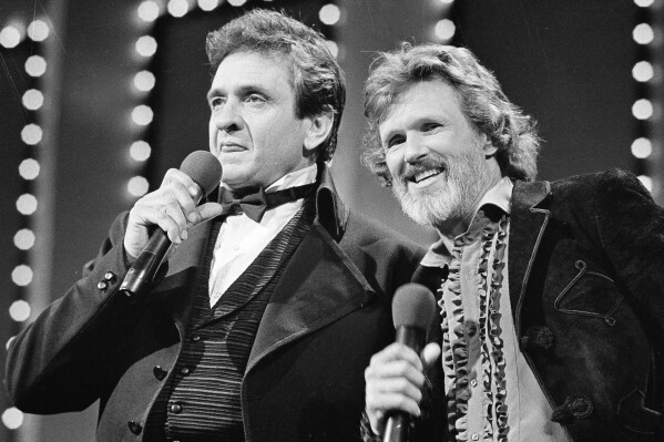 FILE - Country stars Johnny Cash, left and Kris Kristofferson sing during the Country Music Awards in Nashville, Tenn., Oct. 1983. Kristofferson, a Rhodes scholar with a deft writing style and rough charisma who became a country music superstar and A-list Hollywood actor, has died Saturday, Sept. 28, 2024. (AP Photo, File)