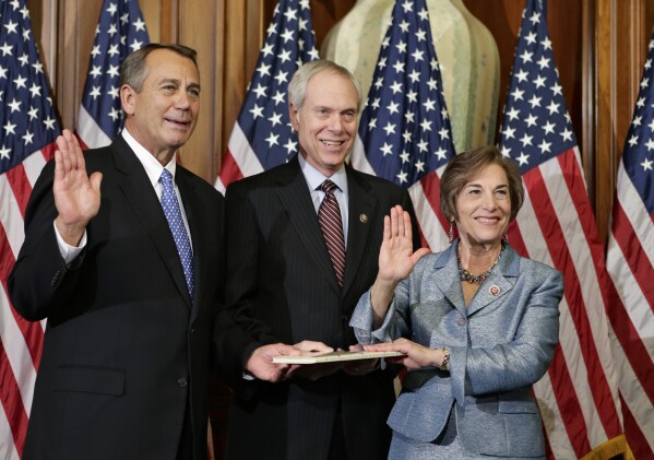 FILE - Rep. Jan Schakowsky, D-Ill., with her husband Robert Creamer, center, stands for a ceremonial photo with Speaker of the House John Boehner, R-Ohio, left, in the Rayburn Room of the Capitol after the 113th Congress convened, Jan. 3, 2013, in Washington. (AP Photo/J. Scott Applewhite, File)