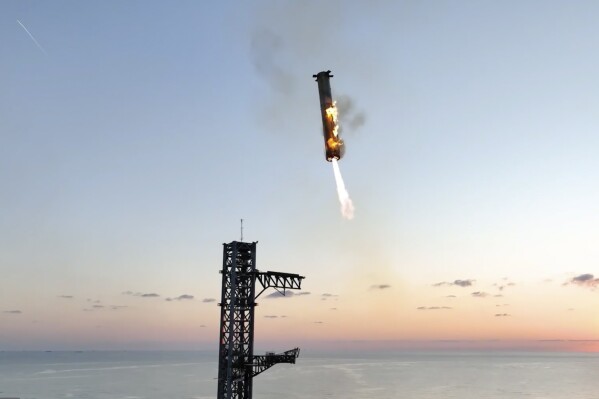 This image provided by SpaceX shows SpaceX's mega rocket booster returning to the launch pad to be captured during a test flight Sunday, Oct. 13, 2024, in Boca Chica, Texas. (SpaceX via AP)