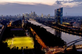 FILE - The European Central Bank stands at right as soccer players practise on a field next to the river Main, in Frankfurt, Germany, late Thursday, Sept. 19, 2024. (AP Photo/Michael Probst, File)