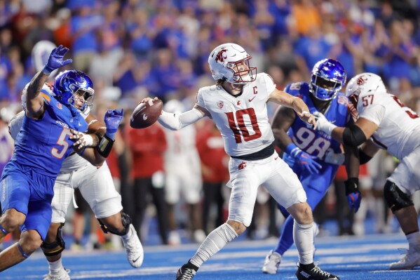 Washington State quarterback John Mateer (10) throws the ball while pressured by Boise State defensive end Jayden Virgin-Morgan (5) late in the second half of an NCAA college football game, Saturday, Sept. 28, 2024, in Boise, Idaho. (AP Photo/Steve Conner)