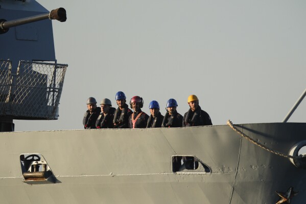 Security official stands on the Italian navy ship Libra as it arrives at the port of Shengjin, northwestern Albania Wednesday, Oct. 16, 2024, carrying the first group of migrants who were intercepted in international waters. (AP Photo/Vlasov Sulaj)