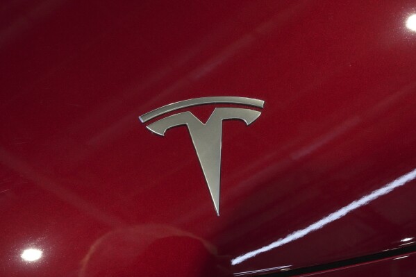 The logo of Tesla car is pictured at the Paris Auto Show, in Paris, Monday, Oct. 14, 2024. (AP Photo/Michel Euler)