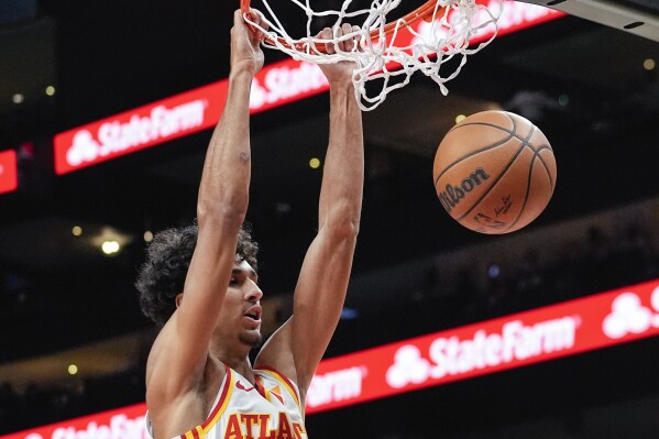 Atlanta Hawks forward Zaccharie Risacher (10) scores in the first half of a preseason NBA basketball game against the Philadelphia 76ers Monday, Oct. 14, 2024, in Atlanta. (AP Photo/John Bazemore)