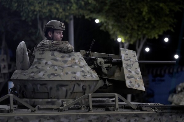 FILE - A Lebanese army soldier sits behind his weapon on the top of an armored personnel carrier at the site of an Israeli airstrike in Beirut's southern suburb, Monday, Sept. 23, 2024. (AP Photo/Bilal Hussein, File)