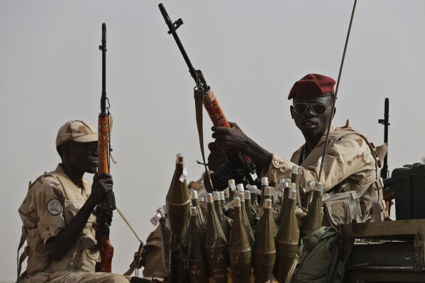 FILE - Sudanese soldiers from the Rapid Support Forces unit, led by Gen. Mohammed Hamdan Dagalo, the deputy head of the military council, secure the area where Dagalo attends a military-backed tribe's rally, in the East Nile province, Sudan, on June 22, 2019. (AP Photo/Hussein Malla, File)