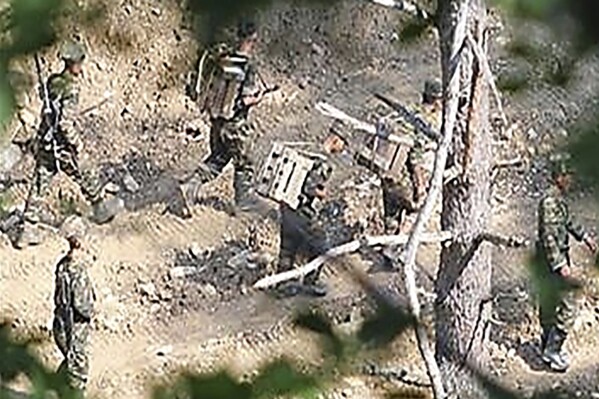 In this undated photo provided on Wednesday, July 17, 2024, by the South Korea Defense Ministry, North Korean soldiers work at an undisclosed location near the border area, as seen from a South Korean guard area. North Korean land mines could be swept into South Korea by flooding, South Korea's military warned Wednesday after the North has recently placed tens of thousands of additional deadly explosives along the rivals' heavily fortified border. (South Korea Defense Ministry via AP)