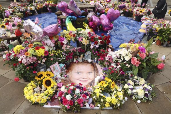 A photo of Elsie Dot Stancombe is seen among the flowers and tributes outside the Atkinson Art Centre in Southport, England, Friday Aug. 23, 2024. The funeral of the seven-year-old took place on Friday at St John's Church in Birkdale. (Paul Currie/PA via AP)