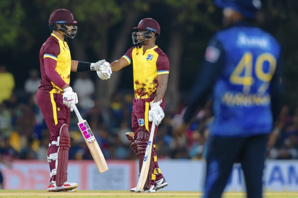 West Indies' Brandon King and Evin Lewis bump fists during the first Twenty20 cricket match between Sri Lanka and West Indies in Dambulla, Sri Lanka, Sunday, Oct. 13, 2024. (AP Photo/Viraj Kothalawala)