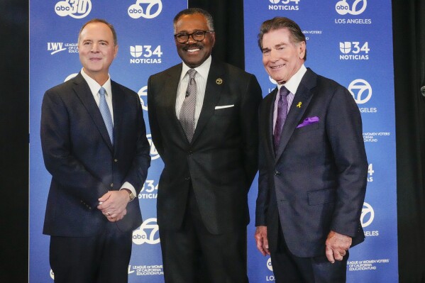 U.S. Rep. Adam Schiff, D-Calif., left, and Republican Steve Garvey, right, pose with moderator KABC news anchor Marc Brown, as both candidates for the U.S. Senate, participate in a debate, Tuesday, Oct. 8, 2024, in Glendale, Calif. (AP Photo/Damian Dovarganes)