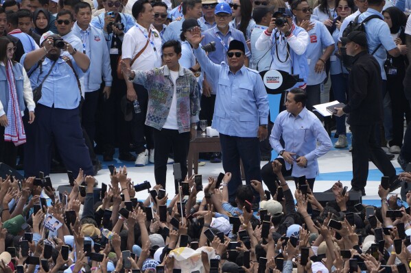 Presidential candidate Prabowo Subianto, centre right, and his running mate Gibran Rakabuming Raka, the eldest son of Indonesian President Joko Widodo, greet their supporters during their campaign rally at Gelora Bung Karno Main Stadium in Jakarta, Indonesia, Saturday, Feb. 10, 2024. (AP Photo/Dita Alangkara)