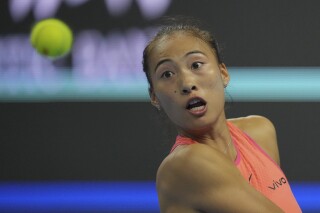 Zheng Qinwen of China eyes the ball from Mirra Andreeva of Russia during the women's singles quarterfinals match of the China Open tennis tournament, at the National Tennis Center in Beijing, Friday, Oct. 4, 2024. (AP Photo/Achmad Ibrahim)