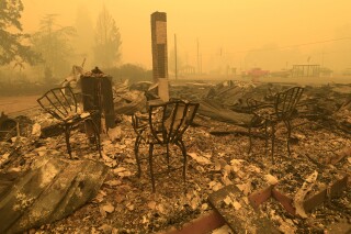 FILE - Chairs stand at the Gates post office in the aftermath of a fire in Gates, Ore., Sept 9, 2020. Oregon utility regulators have rejected a request from PacifiCorp that sought to limit its liability in wildfire lawsuits. KGW reports that the proposal would have limited the company's wildfire liability to just economic damages. (Mark Ylen/Albany Democrat-Herald via AP, File)