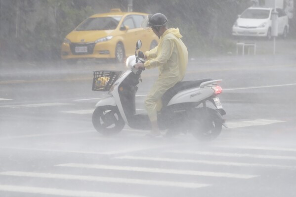 A man struggles in the heavy wind and rain generated by Typhoon Krathon in Kaohsiung, southern Taiwan, Thursday, Oct. 3, 2024. (AP Photo/Chiang Ying-ying)