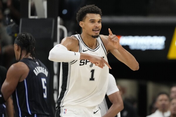 San Antonio Spurs center Victor Wembanyama (1) reacts to a score against the Orlando Magic during the first half of a preseason NBA basketball game in San Antonio, Wednesday, Oct. 9, 2024. (AP Photo/Eric Gay)